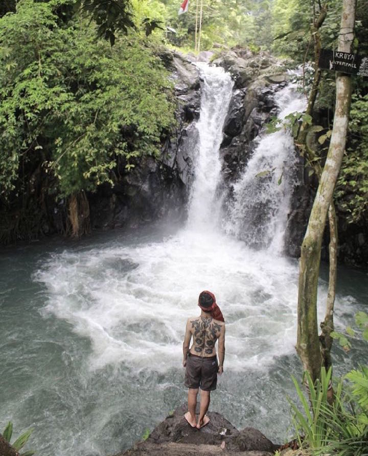 Man with Kalimantan tattoos backpiece waterfall in North Bali 