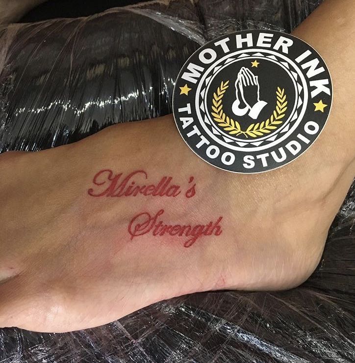 Red cursive lettering tattoo by Mother Ink