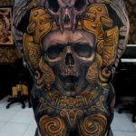 Skull backpiece black and gold tattoo by Ata Ink in Bali