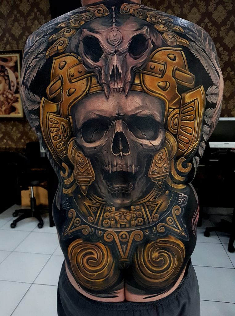 Skull backpiece black and gold tattoo by Ata Ink in Bali