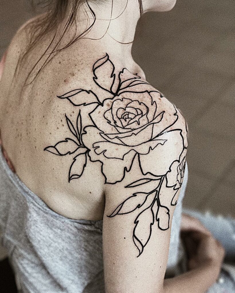 rose line tattoo on woman's shoulder 