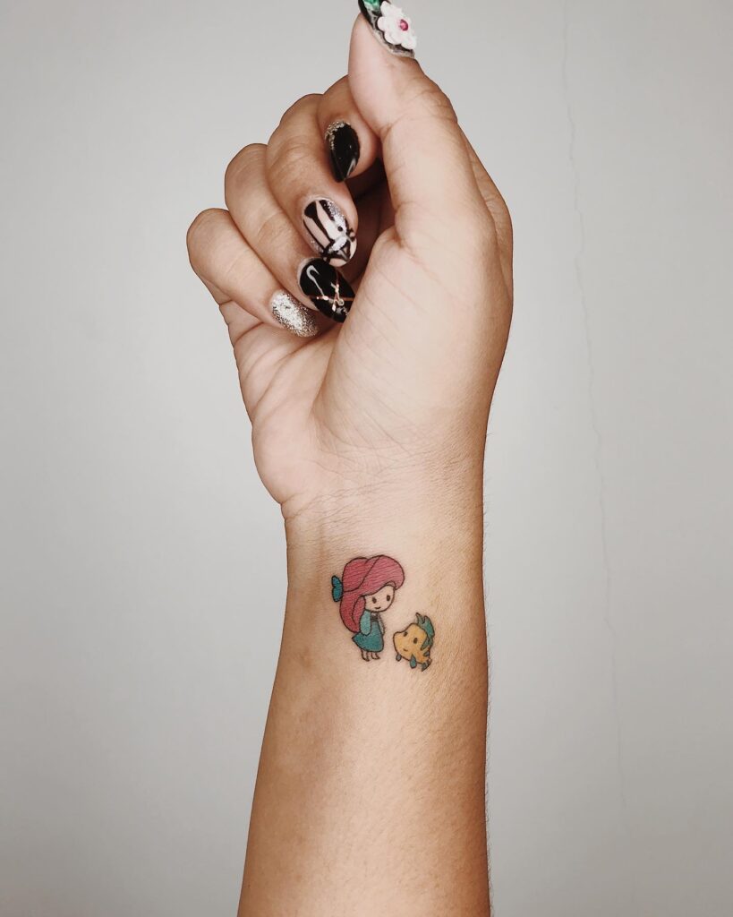 Small color wrist tattoo of Ariel and Flounder by Ilo, March 2020 - Canggu, Bali